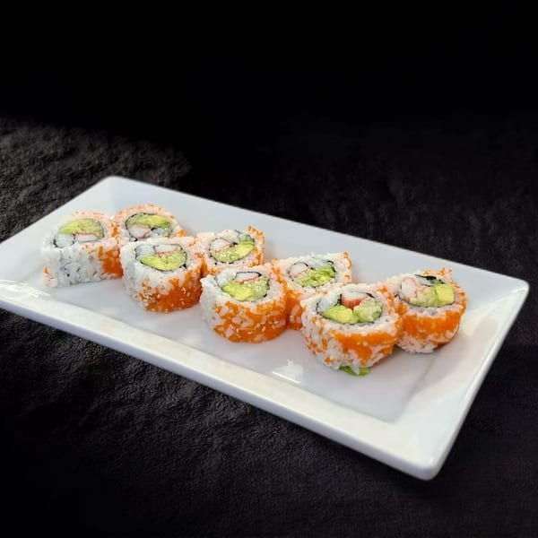 California sushi rolls with avocado, crab, and roe on a white rectangular plate.